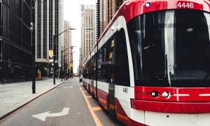 A downtown scene with a train in the middle of a major road
